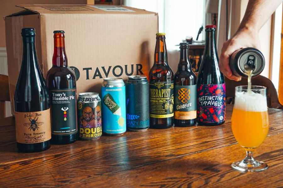 Tavour beer subscription box on table and hand pouring beer